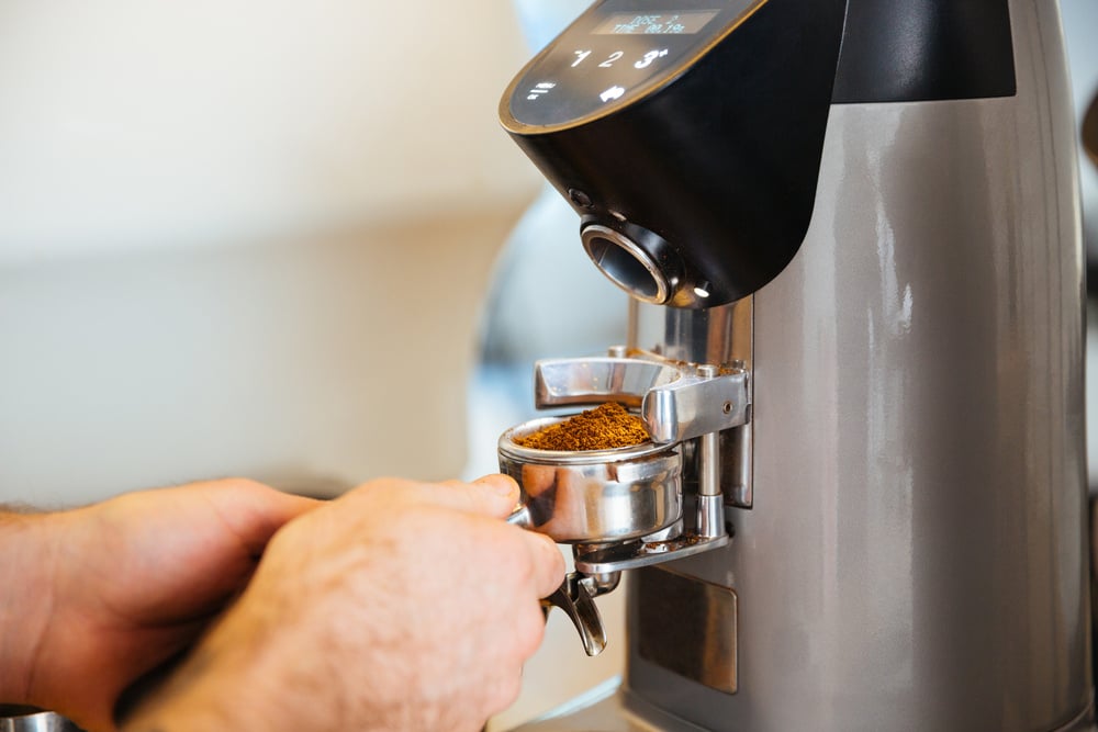 Closeup portrait of barista grinding coffee